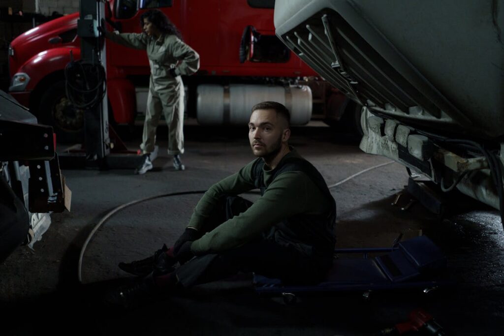 Auto Mechanic sitting under a Car